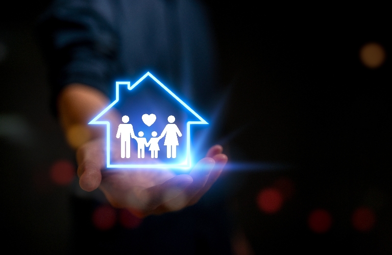 man holding virtual icon of house with family inside